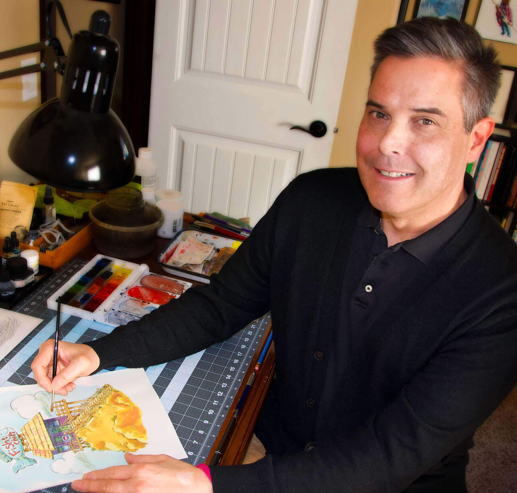 Tom Shannon, illustrator, smiling while working in his studio